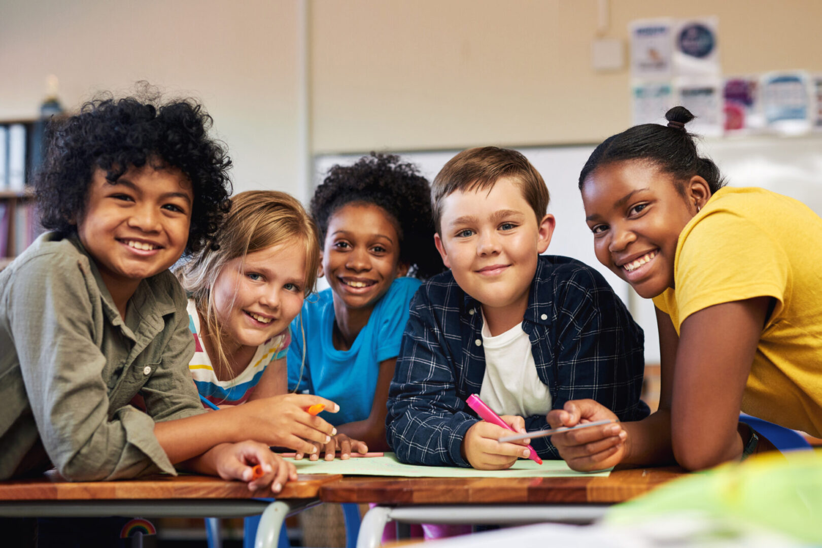 A diverse group of smiling children sitting together at a table.