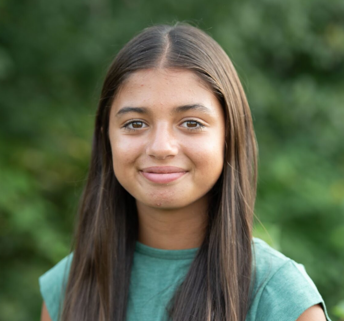 Portrait of a young woman smiling softly outdoors.