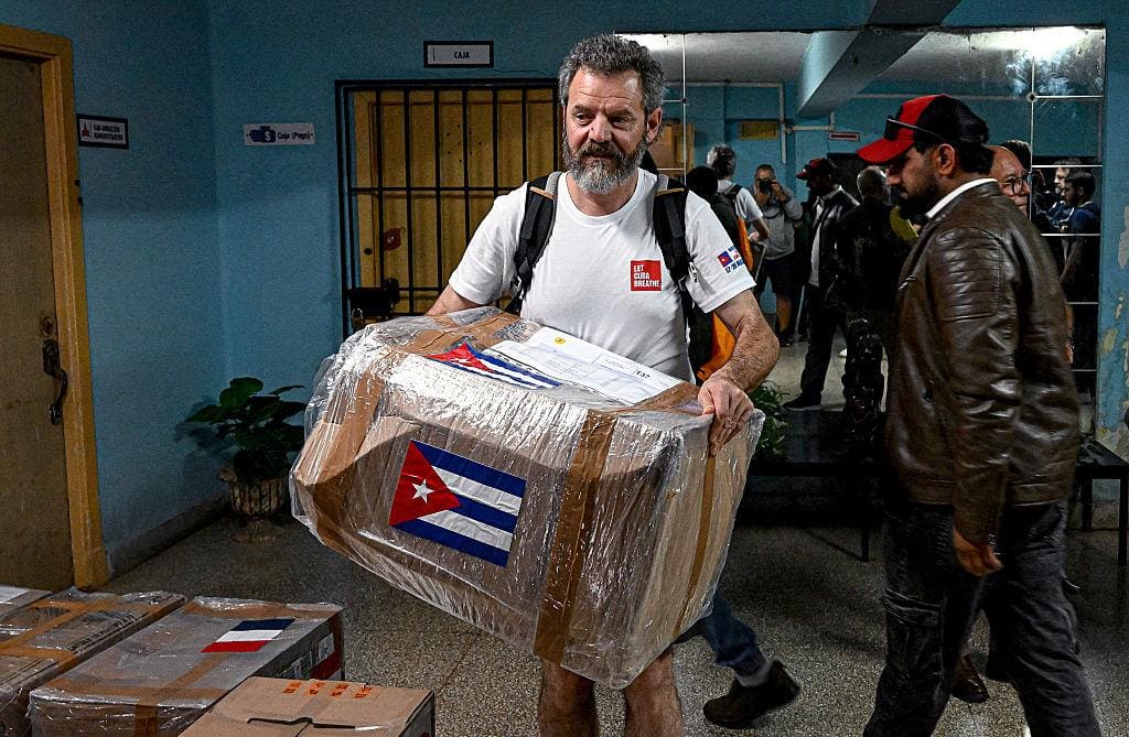 Man carrying wrapped box with Cuban flag