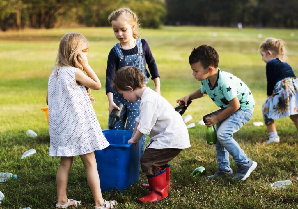 Four children playing together outdoors on a sunny day.