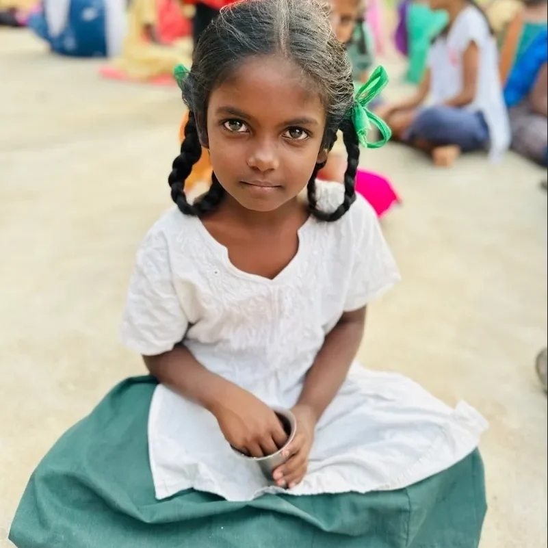 Young girl with braided hair holding a cup