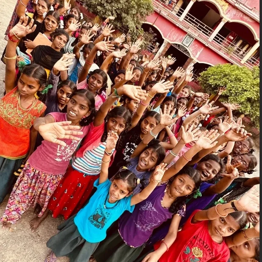 Group of smiling children waving outdoors